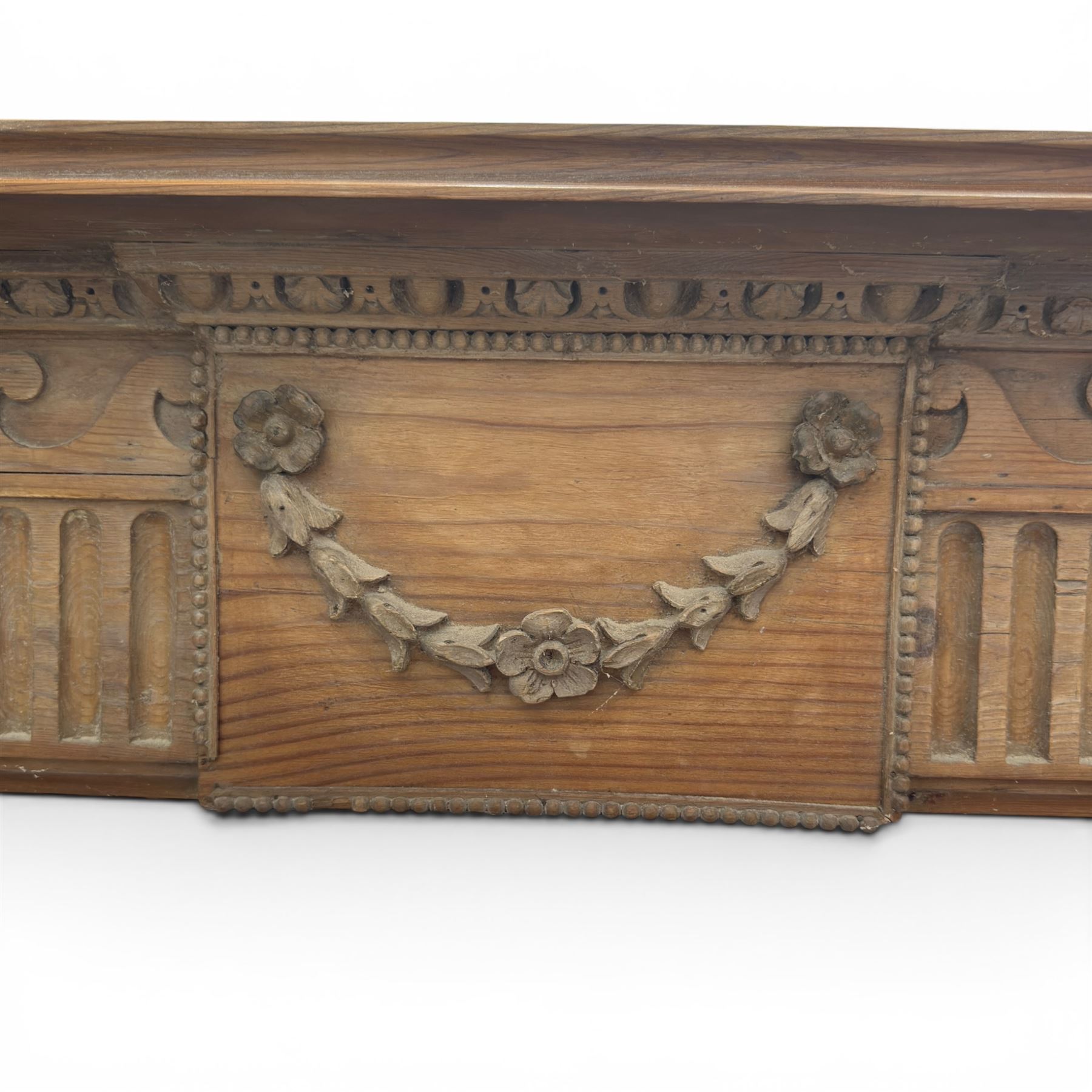19th century Adams design pine fire surround, egg-and-dart carving over Vitruvian scrolls and fluted frieze, decorated with applied carved festoons and garlands, on fluted uprights