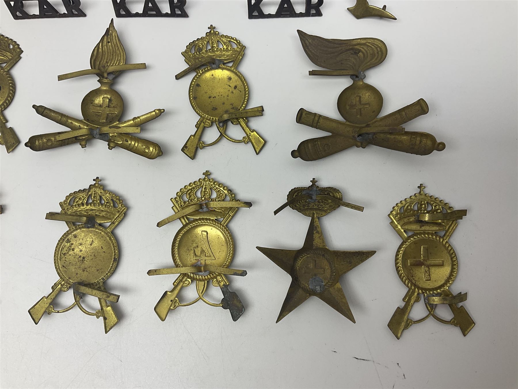 Over thirty British and Continental military metal badges; together with quantity of shoulder titles, collar dogs, rank pips, uniform buttons etc