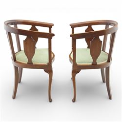 20th century mahogany tub chairs, the arched backs enclosing shaped splat panels and plain uprights, open curved arms flowing into the seat rails, upholstered seats in green foliate patterned fabric, on cabriole legs