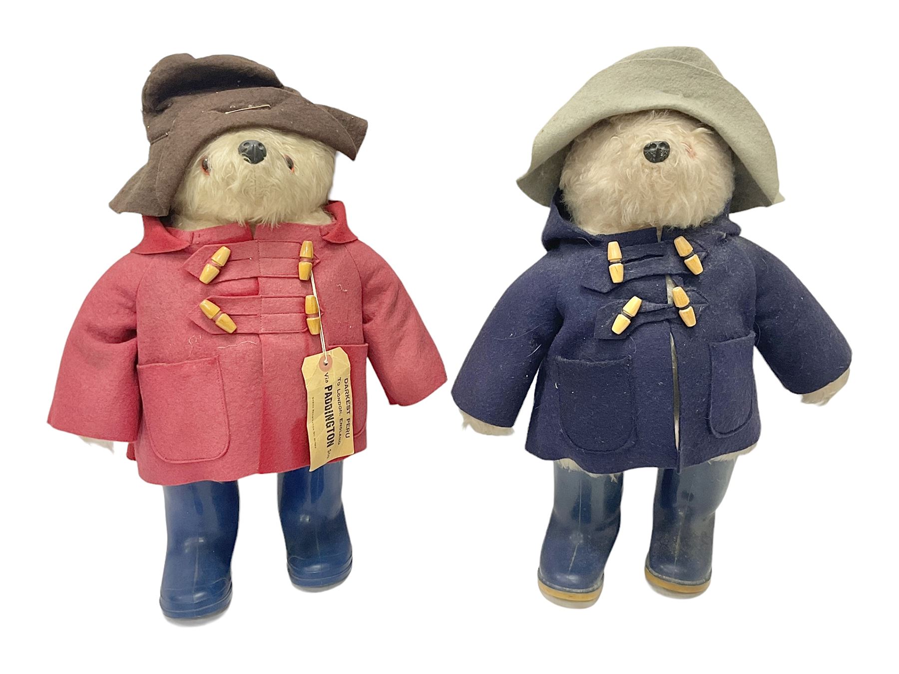 Pair of Paddington Bear teddies with amber eyes, the first example having a brown felt hat, red coat and blue PB boots with original label; the second having a grey felt hat, blue coat and blue Dunlop boots, tallest H51cm 