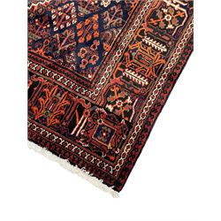 Persian Joshaghan red ground rug, stepped lozenge medallion surrounded by small lozenge motifs, the border decorated with stylised plant motifs within patterned guard stripes