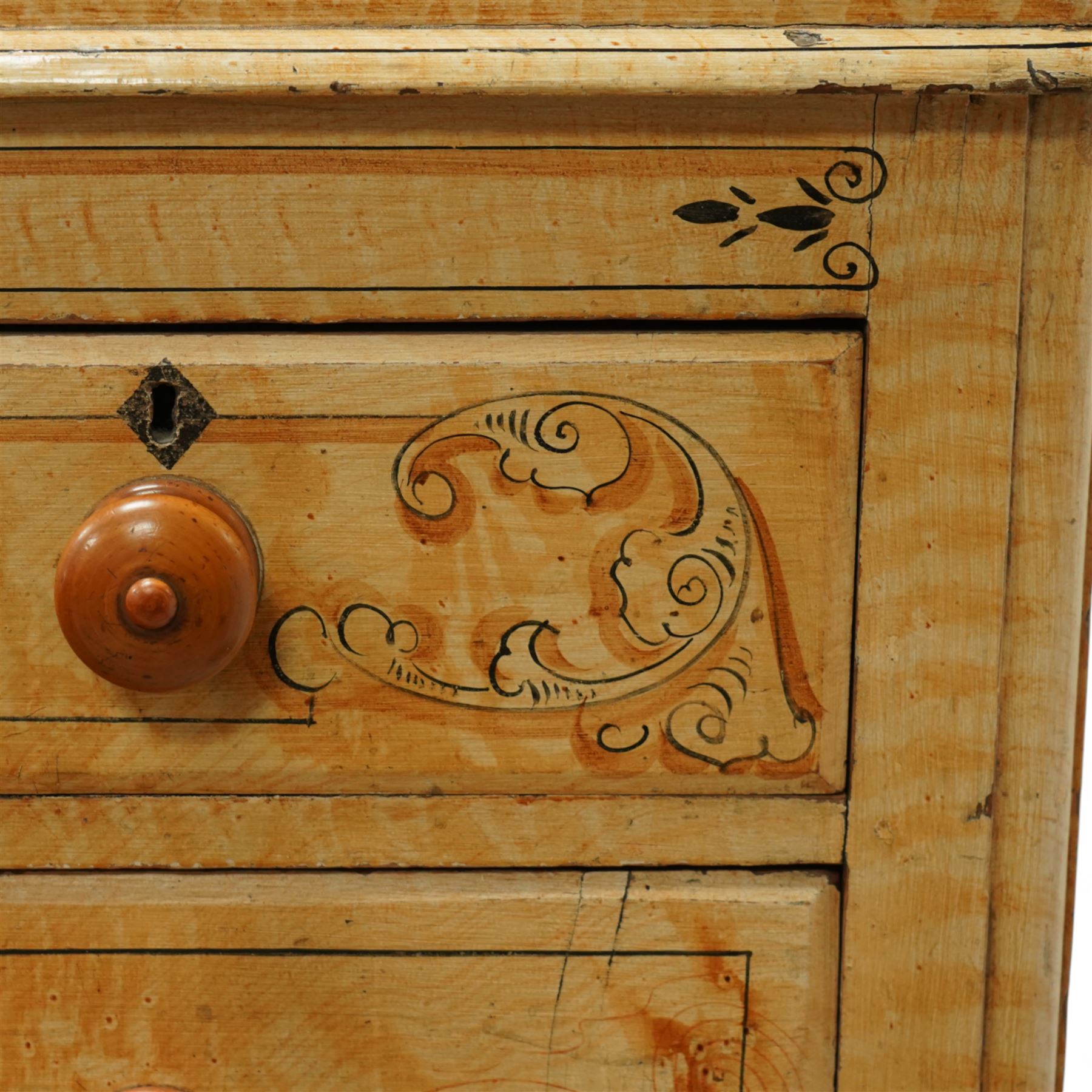 19th century pine painted chest of drawers, rectangular moulded top above two short and three graduated long drawers, each with painted foliate scroll and line detailing, turned knobs, and concealed turned feet, the sides with rounded corners and ebonised detail