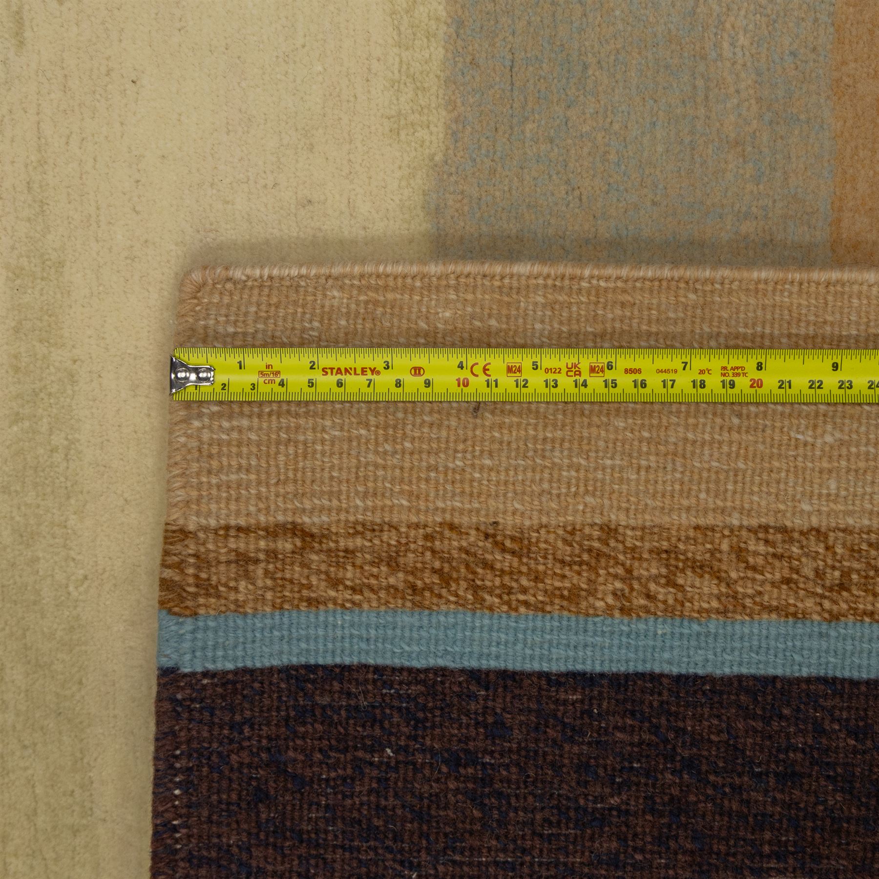 Rugs by Design - ‘Sand Bar’ Nepalese thick pile wool rug, with abstract horizontal bands in cream, blue, camel and dark brown tones, centred by a narrow multicoloured vertical stripe