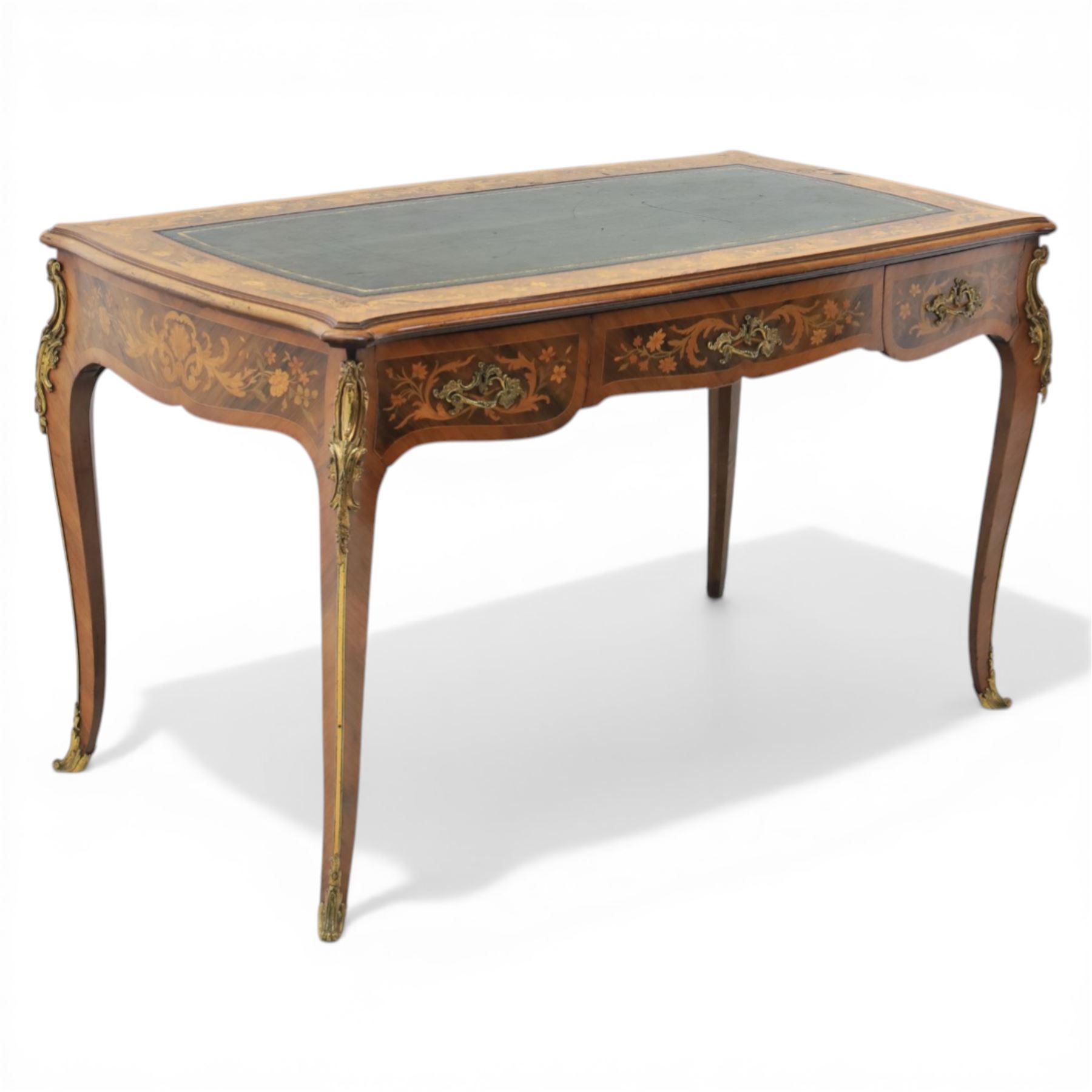 Late 19th century French kingwood and marquetry bureau plat, the serpentine rectangular top with green leather inset writing surface within crossbanded and foliate marquetry border, above a shaped frieze fitted with three drawers with floral marquetry panels and gilt metal handles, upon cabriole supports with applied gilt metal mounts and sabots