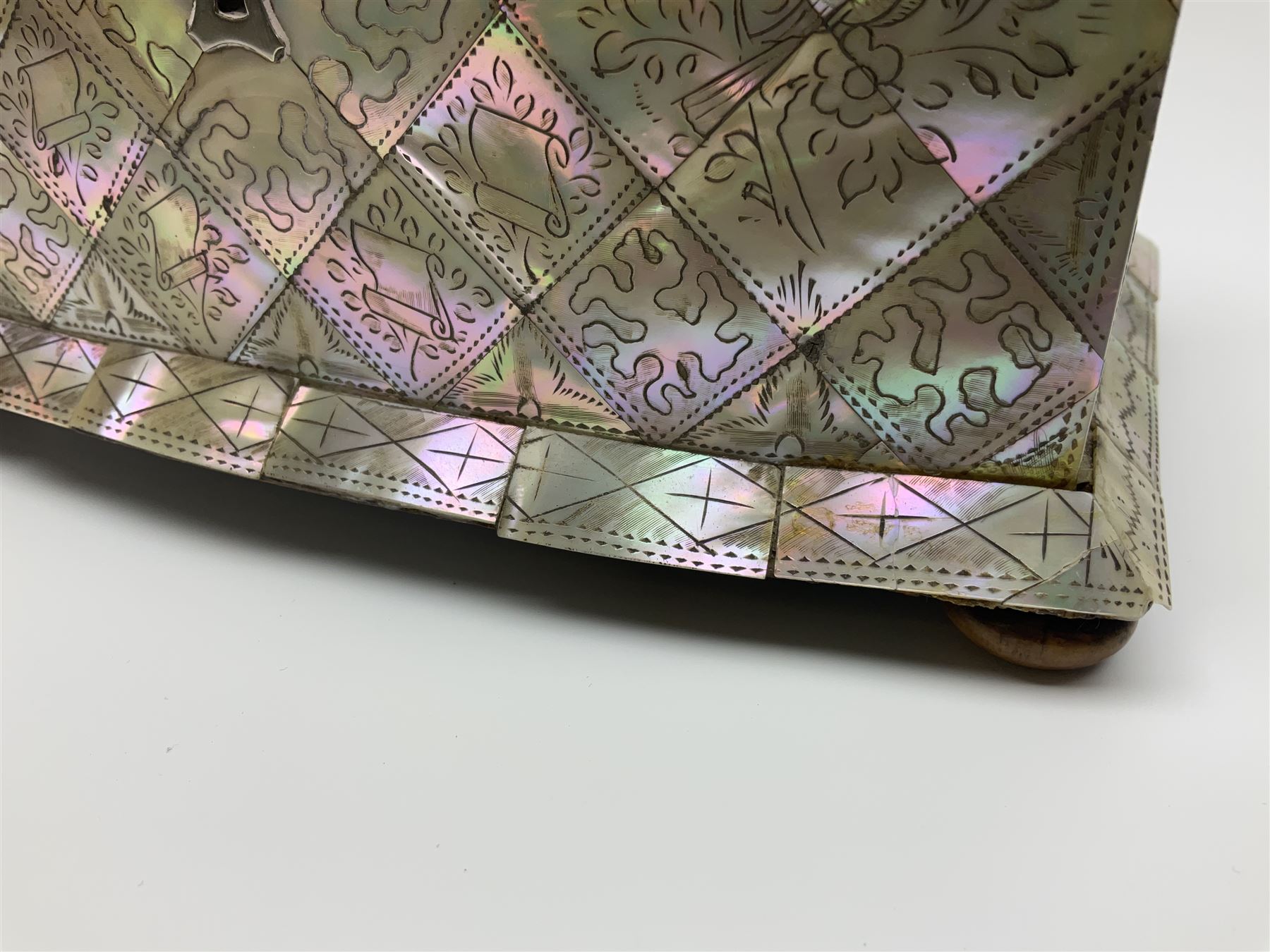 Victorian mother of pearl tea caddy, of rectangular bow-fronted form, the body with floral, bird and geometric engraved mother of pearl panels, white metal shield plaque to the cover inscribed with the initials G.J.A and similar escutcheon, the two division interior with ivory edging and two panelled mother of pearl lids, on four vegetable ivory bun feet L20cm, together with a similar style mother of pearl card case (2) This item has been registered for sale under Section 10 of the APHA Ivory Act