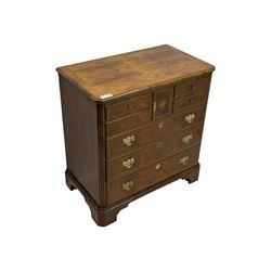 Late 20th century walnut veneered television chest in Georgian style, rectangular top over simulated drawer front with central marquetry star inlay, opening to a shelved TV compartment, lower section fitted with one long drawer, brass handles and ogee bracket feet
