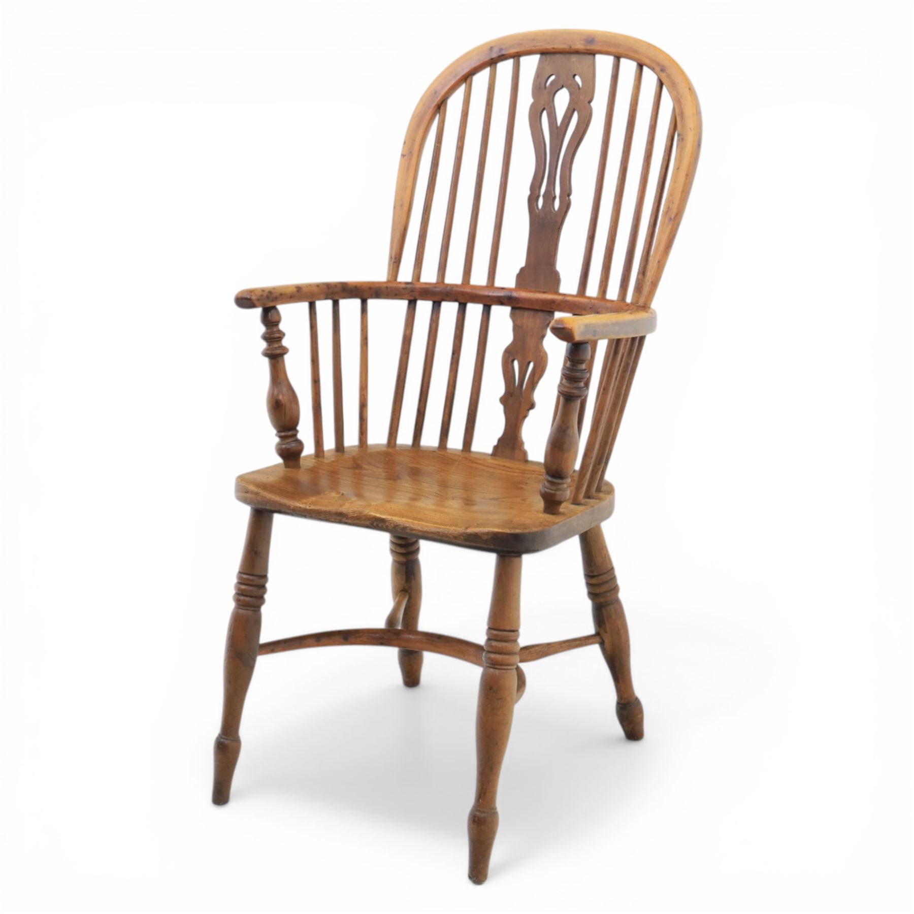 Early 20th century yew wood Windsor armchair, hooped back with spindle supports and shaped pierced central splat, solid seat with shaped edge, turned arm supports, on turned legs united by crinoline stretcher