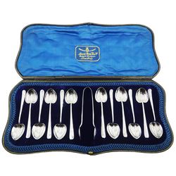 Late 19th/early 20th century set of twelve Arts & Crafts style silver rat tail coffee spoons with heart shaped bowls, and pair of sugar tongs, hallmarked Atkin Brothers, Sheffield 1899, 1919 and 1920, contained within a fitted case with blue silk and velvet lining, approximate total silver weight 3.63 ozt (113 grams)