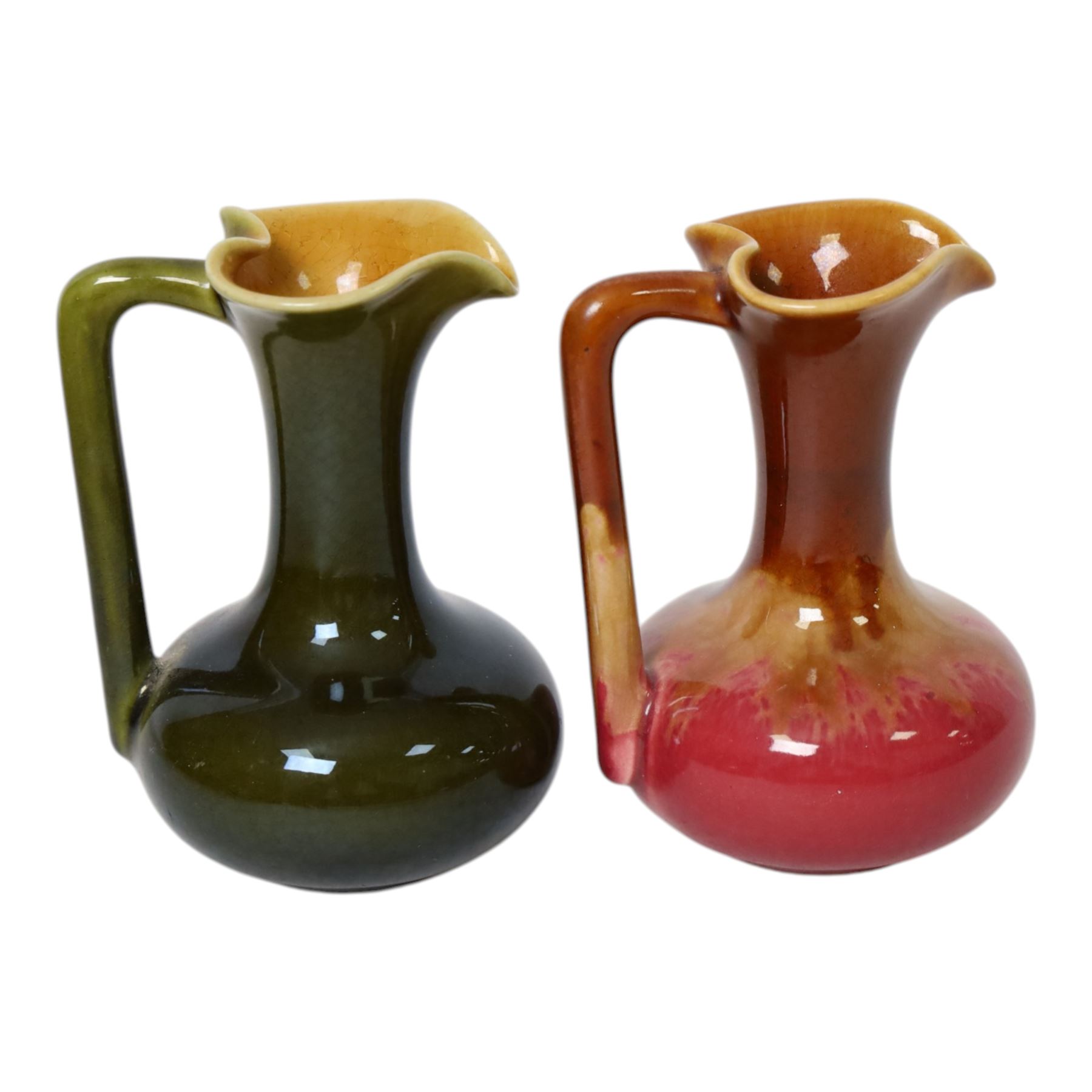 Christopher Dresser for Linthorpe Pottery, two of miniature jugs in red and green, shape number 850, with impressed mark beneath, H9cm