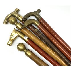 A group of six walking canes, to include two novelty examples with knopped screw threaded handles, the interiors containing snooker cues, an example with curved screw threaded handle opening to reveal a glass vial to the interior, an example with brass handle modelled as a horses head, another modelled as a ducks head, etc. 