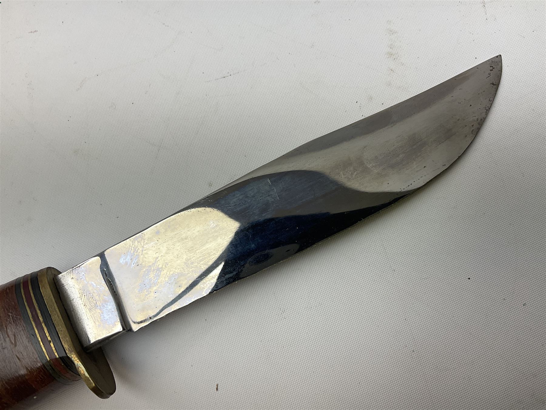 Graduated set of three Bowie knives by J. Nowill & Sons Sheffield England Est. AD1700, each with steel blade, brass cross-piece, stacked leather type grip and alloy pommel; largest blade 13cm and smallest 7.5cm; each in leather sheath (3)