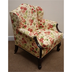  Early Victorian mahogany framed low armchair, arched wing back and loose seat cushion upholstered in vintage floral Sotherton fabric by Nouveau, cabriole legs with scroll feet and recessed brass castors,   
