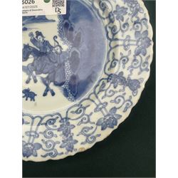 Chinese Kangxi style blue and white plate, decorated to the centre with a hunting scene  of two hunters on horse back, surrounded by a foliate boarder, with with six character double ring mark beneath