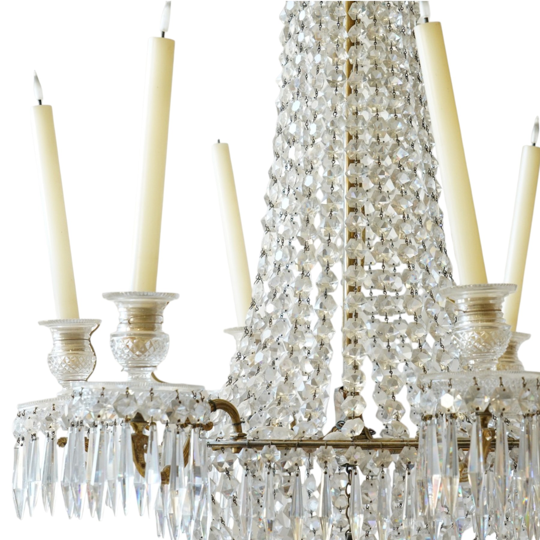 Regency Country House cut-glass and ormolu six light chandelier, the outer shaft with ormolu foliate moulding hung with octagonal and drop pendants, the impressive central shaft with cascading drops of cut-glass, the scroll branches with hob-nail cut candle holders and wax pans, with central similarly cut terminal
Provenance: property of a nobleman