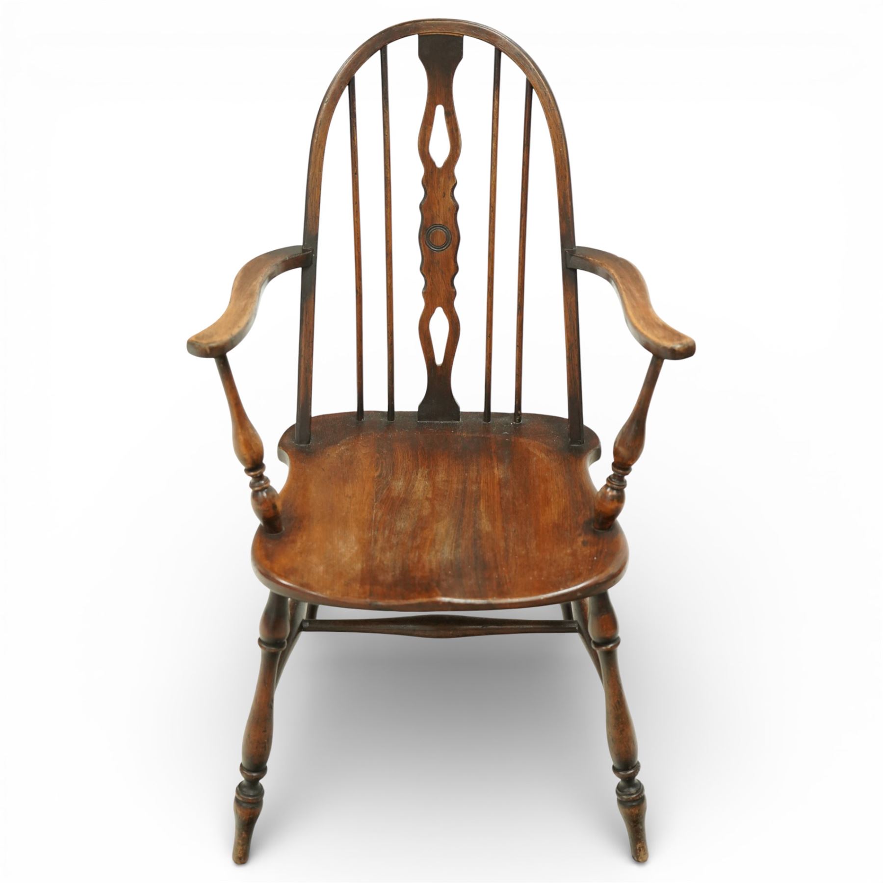 Early 20th century Windsor armchair, the arched hoop back enclosing a pierced and shaped splat flanked by turned spindles, above a shaped elm seat and outswept arms on turned supports, raised on turned legs united by an H stretcher