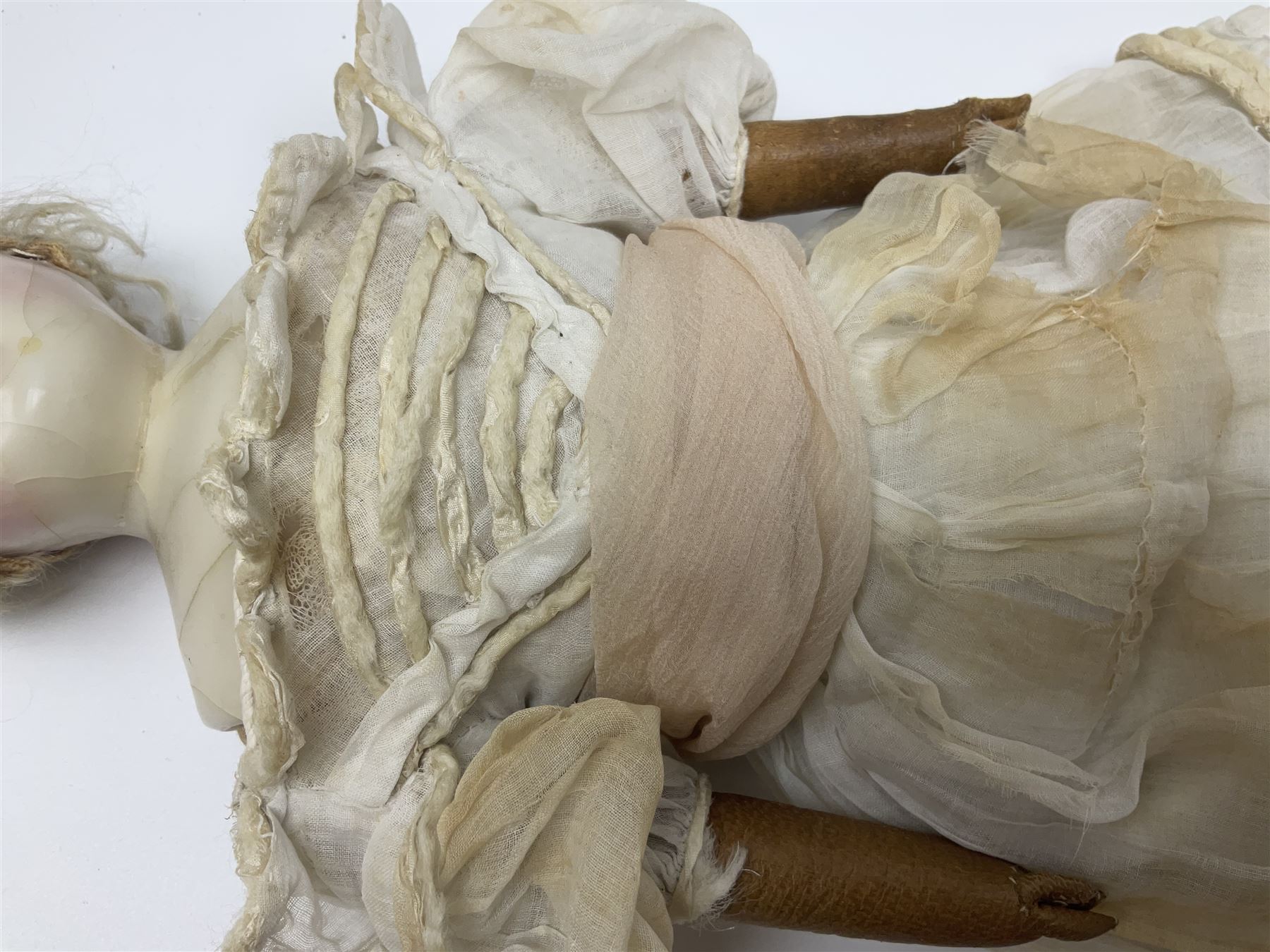 Victorian wax shoulder head doll with pale complexion, applied hair, inset glass eyes and fabric covered jointed body with kid leather lower arms; white linen dress and undergarments H50cm