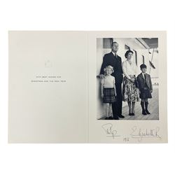 HM Queen Elizabeth II and HRH The Duke of Edinburgh - signed 1956 Christmas card with gilt embossed crown to cover, black and white photograph of the smiling Royal Couple with Prince Charles and Princess Anne on board Britannia, signed in ink 'Philip 1956 Elizabeth R',