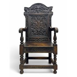 Late 19th century Jacobean revival carved oak armchair, the tall back with arched cresting featuring a stylised foliate mask, flanked by carved scrolls, relief carved panel depicting symmetrical foliage, downscrolled arms, on turned front supports united by stretchers