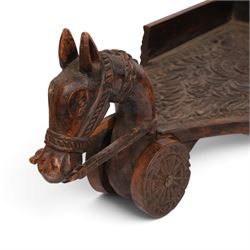 Indian carved wooden tray on wheels, the front carved as a horses head, the cart with foliate details, H28cm