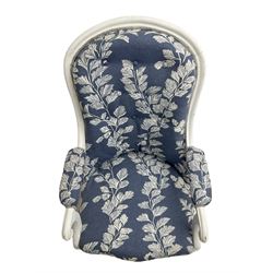Victorian white painted open armchair, upholstered in blue fabric decorated with trailing leaf pattern, scrolled arm terminals on turned front supports with castors