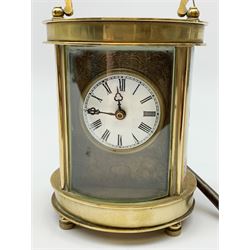 Late 20th Century brass cased carriage time piece clock, oval form set with circular Roman dial and painted enamel panels at each side, arched carrying handle, with key