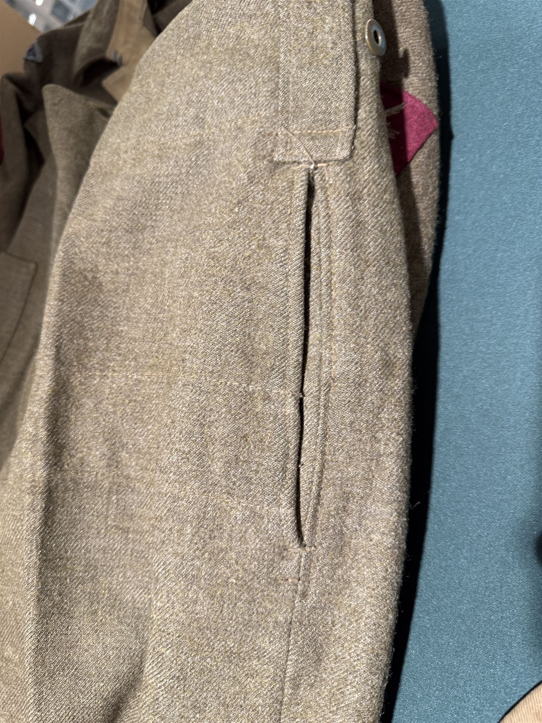 WWII British parachute regiment battle dress uniform, the jacket with shoulder title and Pegasus formation badge to the left arm, shoulder title, Pegasus formation badge and cloth wings to the right, size 3 dated 1943, the trousers size 3 dated 1945 