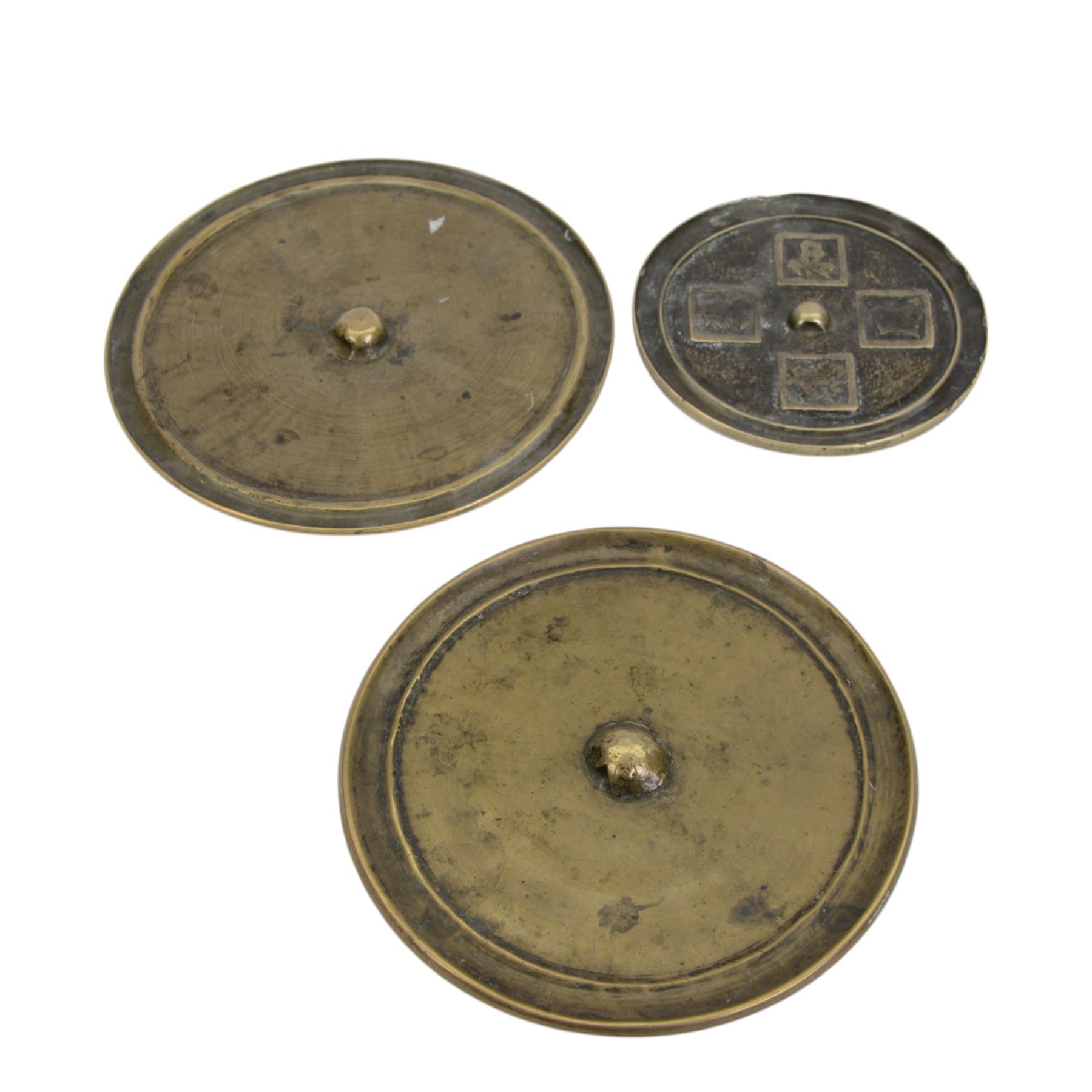 Three Chinese bronze hand mirrors, the smallest decorated in relief with four characters, largest D19cm