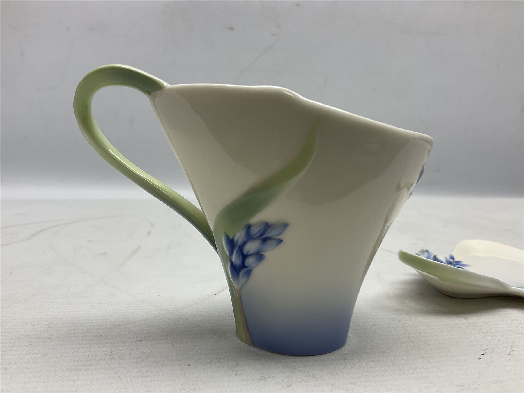 Five Franz teacups and saucers comprising Hummingbird FZ00129, Bluebell FZ00875, Dragonfly FZ00028, Butterfly XP1693 and Daisy FZ00793, together with Hummingbird spoon, all boxed (6)