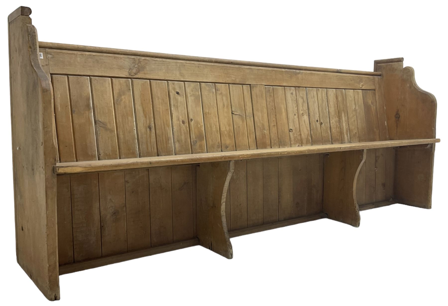Early 20th century pine church pew, vertical plank back over rectangular seat, flanked by shaped end supports, with bible rest to back