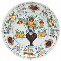 Pair of 18th century English Delft tin glazed plates, of circular form, decorated with stylised flowers in red and yellow, within a border of traditional repeating patterns of foliage and cross-hatching, bearing blue marks to base, D23cm