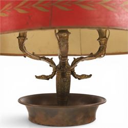 Bouillotte lamp, the adjustable red tole shade above three brass sconces upon a circular dished base, H54cm