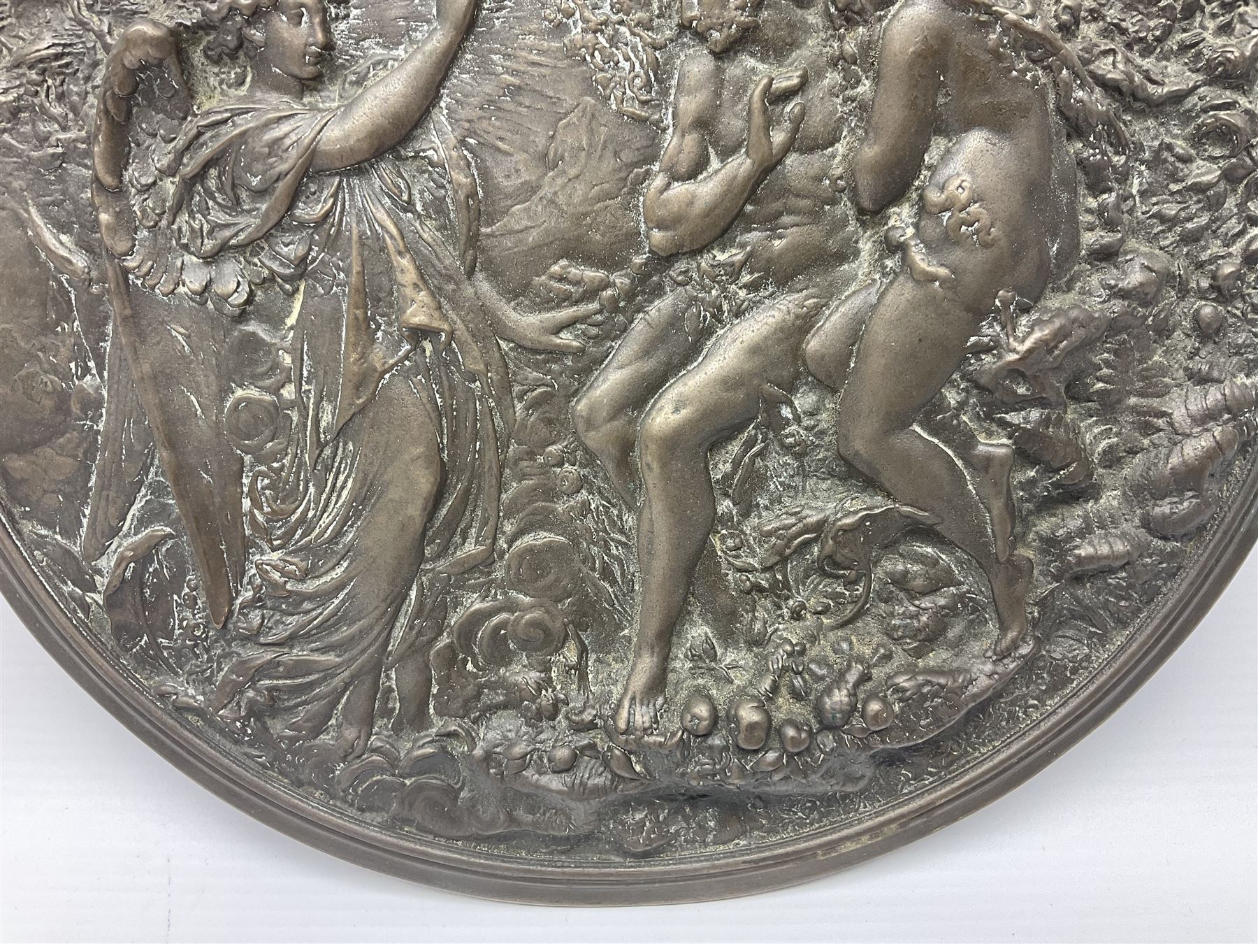 Late 19th century bronze plaque, of circular form, depicting the angel appearing to Adam and Eve in the garden of Eden in high relief, D25.5cm
