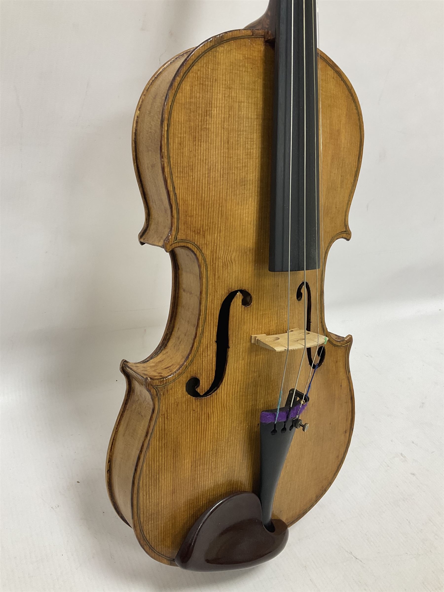 Copy of a full size Stradivarius violin, with an ebonised fretboard, tailpiece and tuning pegs, with a polished chin rest  Length 60cm