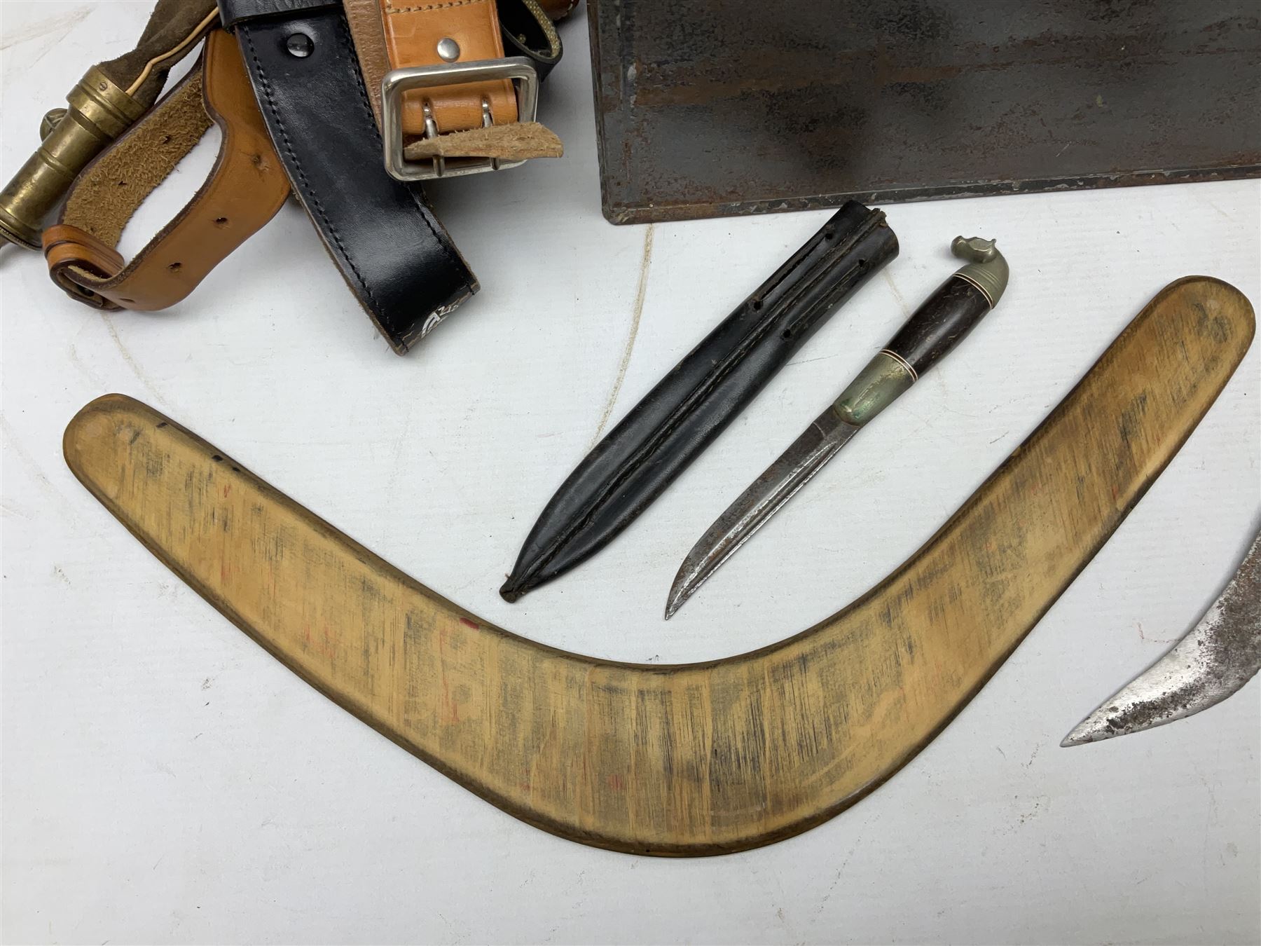 Assorted militaria including ten leather or canvas cartridge and other belts, maroon beret with 17th Lancers cap badge, modern bullet mould, leather and brass shot flask, two knives, shell cases, boomerang etc; in tin deed box