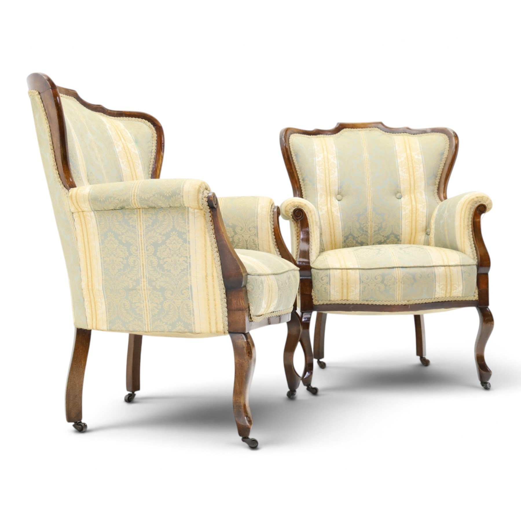 Edwardian mahogany three-piece salon suite, comprising settee and two armchairs, shaped frames with upholstered backs, scrolled arm supports and serpentine seat rails, upholstered in striped floral damask fabric, on cabriole supports with castors (Armchairs: H 96cm, W 70cm, D 68cm)