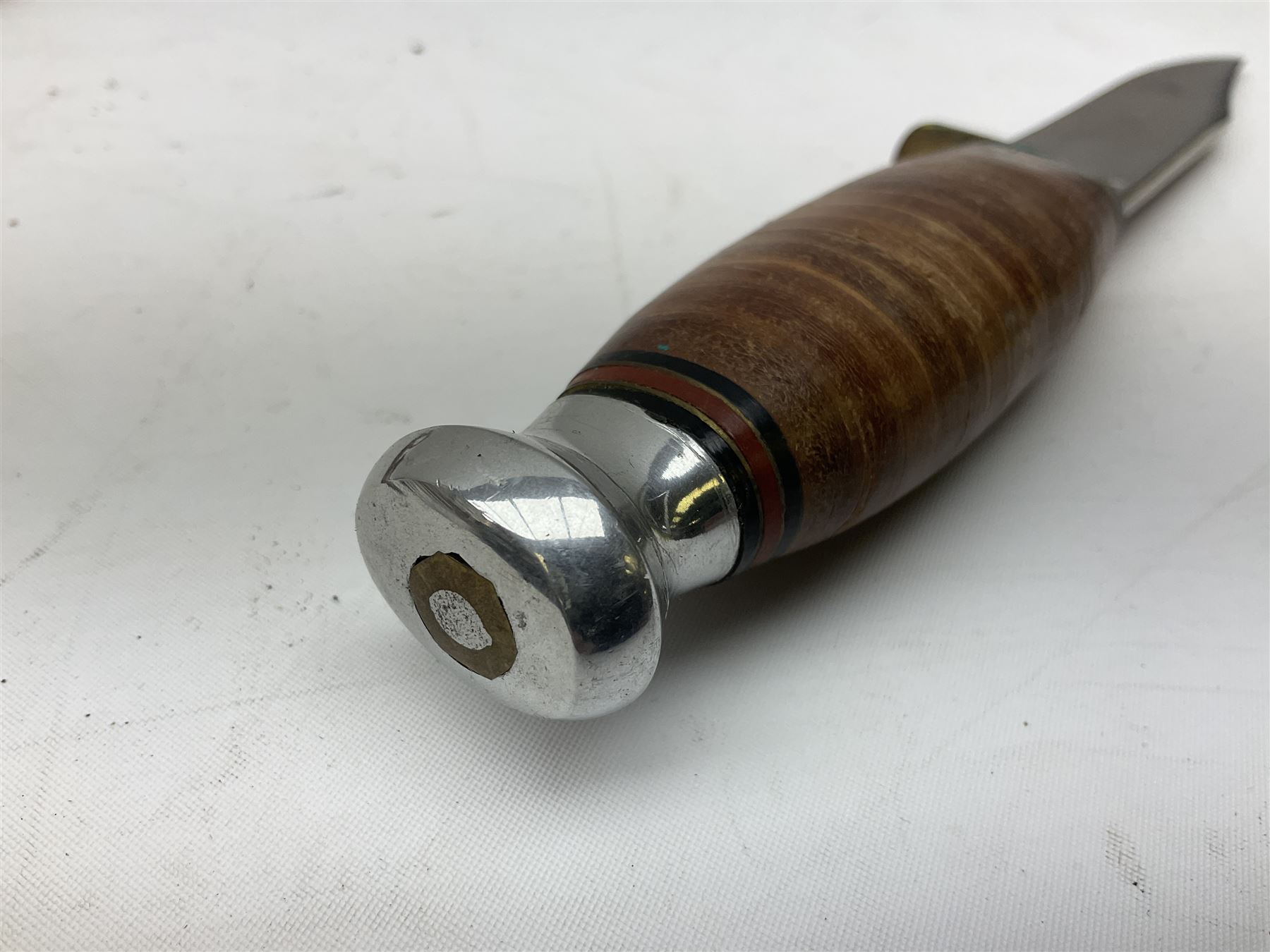 Graduated set of three Bowie knives by J. Nowill & Sons Sheffield England Est. AD1700, each with steel blade, brass cross-piece, stacked leather type grip and alloy pommel; largest blade 13cm and smallest 7.5cm; each in leather sheath (3)