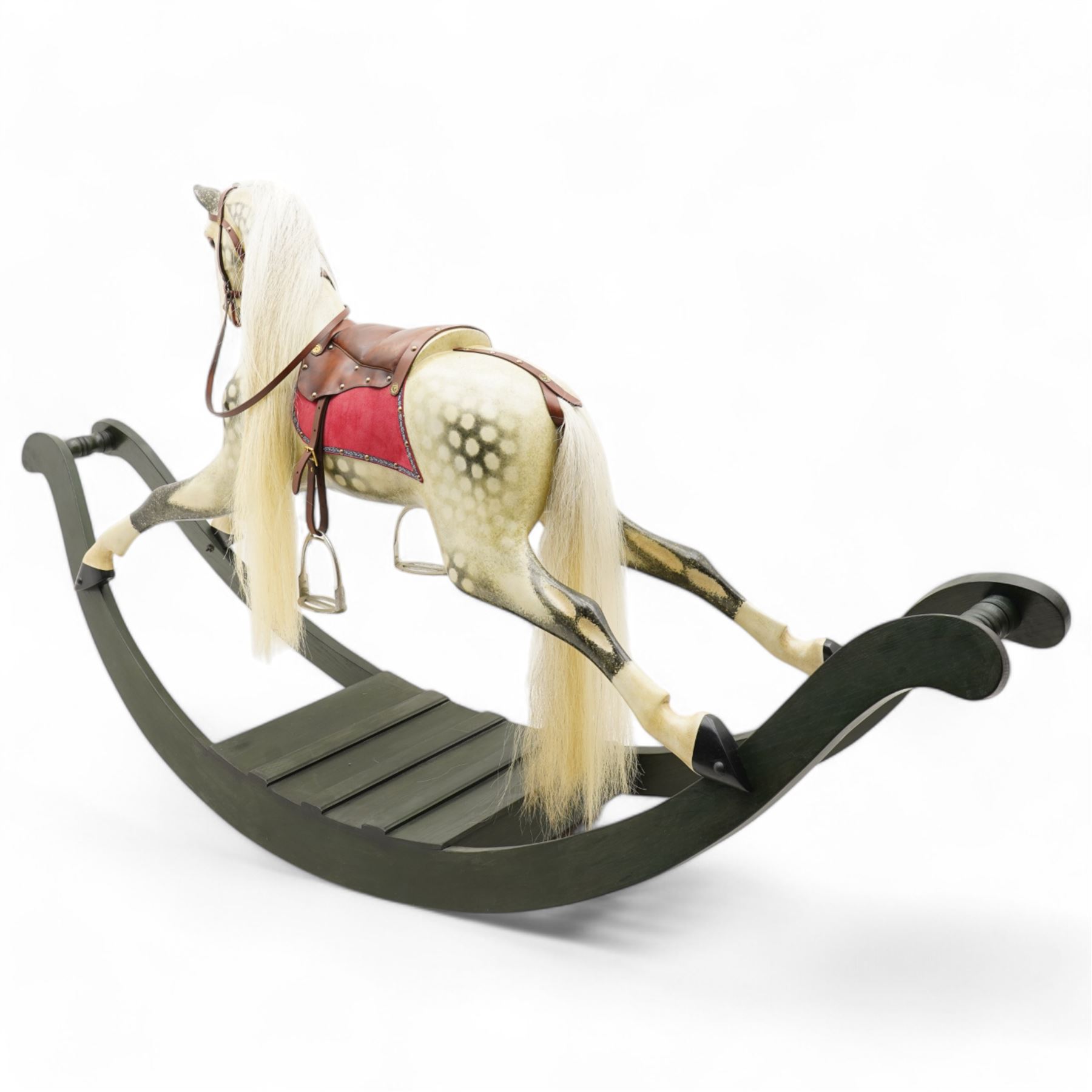 In the manner of F. H. Ayres - large carved wooden rocking horse, in dapple grey paint finish, decorated with glass eyes, leather reins, stirrup and saddle, on bowed rockers united by turned stretchers and boarded base 