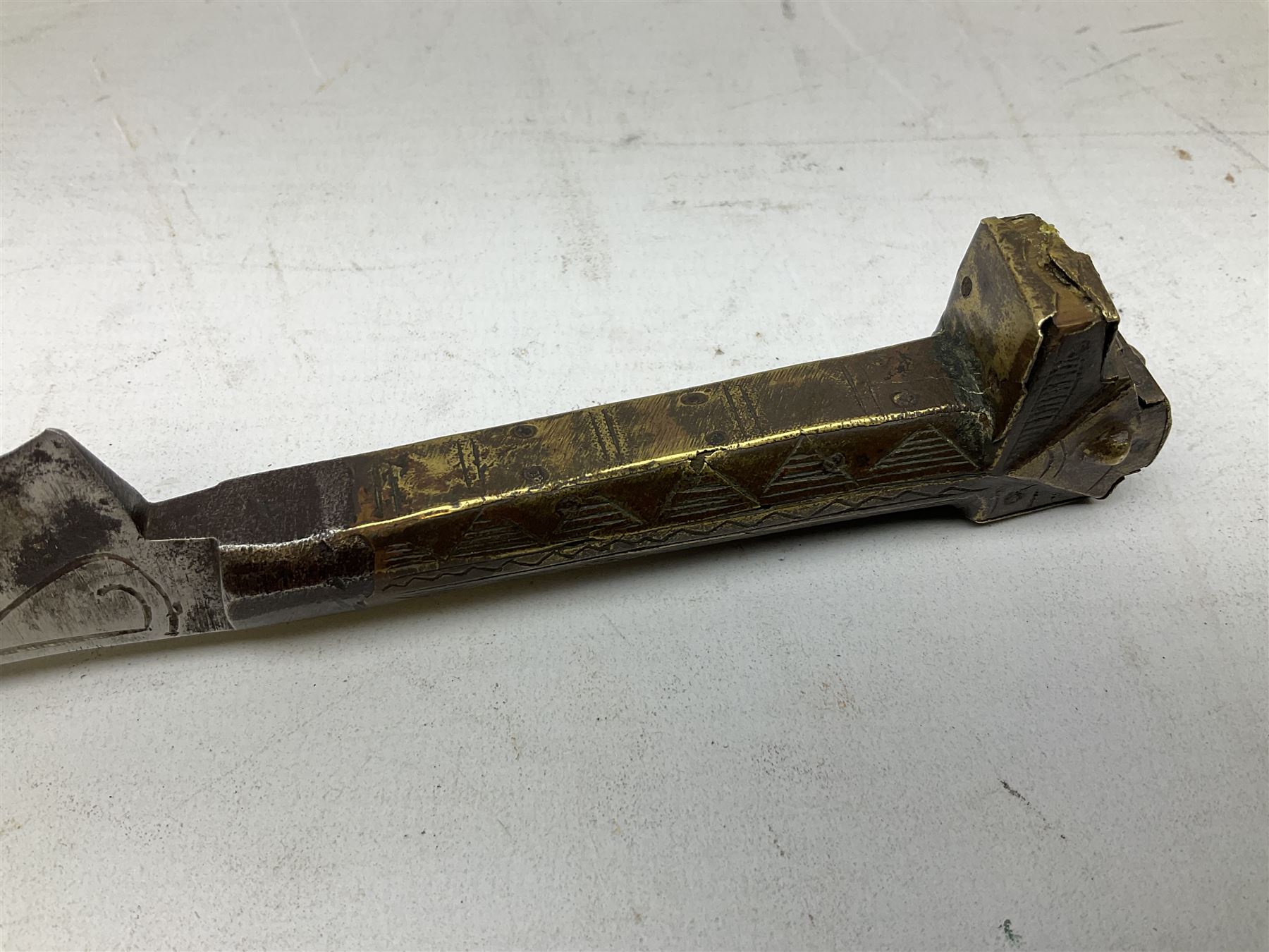 19th century Algerian Flyssa long knife, the 34cm single edged pointed decorative blade inset with yellow metal, chased brass grip with pommel as the snout of a stylised animal and carved hardwood scabbard L45cm overall
