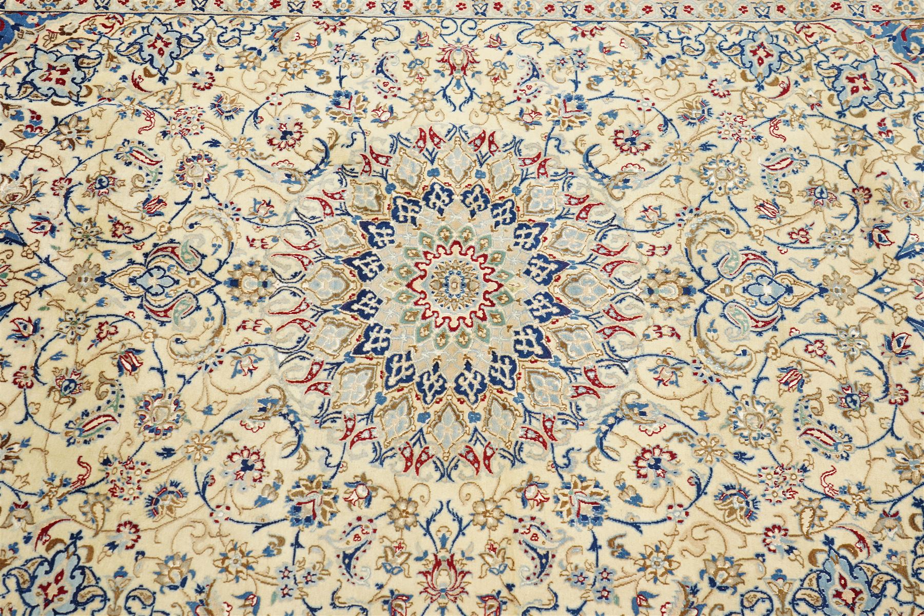 Central Persian Nain hand-knotted carpet, ivory field with central finely drawn cusped medallion of radiating palmette and arabesque form with scrolling vine work, flowering tendrils and stylized foliate motifs in a palette of pale blue, indigo, crimson and sage accents, spandrels of conforming design enclosing intricate floral sprays and arabesques within  multiple borders and narrow guard stripes, with cotton fringe ends 