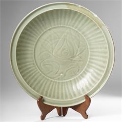 Chinese Ming dynasty Longquan celadon dish, the base carved with a lotus within a ribbed s...