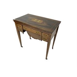 Edwardian inlaid mahogany games or work table, rectangular fold-over top inlaid with stylised dragon ivorine decoration and stringing, fitted with one long flanked by four small drawers over sewing compartment drawer, raised on square tapering supports with castors