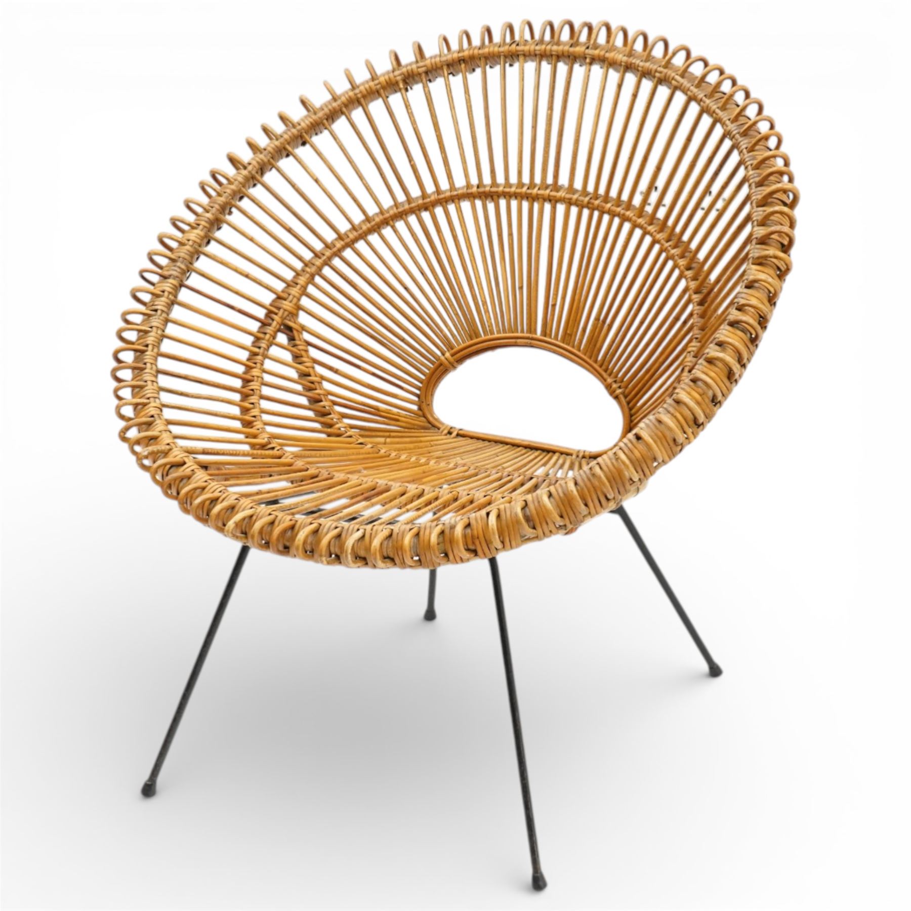 Janine Abraham and Dirk Jan Rol - Mid 20th century rattan sun lounger chair, circular openwork seat and back formed of radiating cane spindles with looped rim, raised on slender black metal tripod supports
