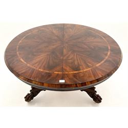 Regency mahogany circular breakfast table, the highly figured segmented veneer top with rosewood band, turned column on platform base with carved paw feet, circular glass top