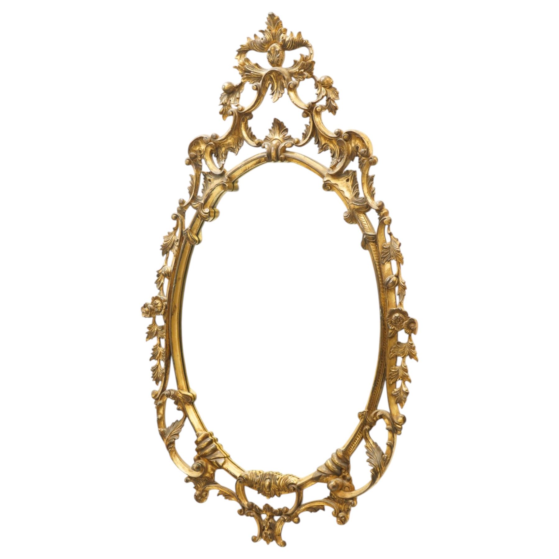 Rococo design giltwood and gesso wall mirror, oval plate within moulded frame, pierced cresting and apron, decorated with acanthus leaves, flowerheads and trailing foliage