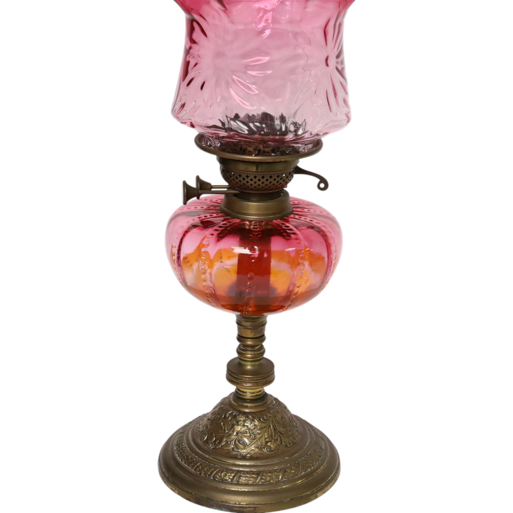 Victorian oil lamp, the brass base supporting cranberry glass reservoir, with clear glass chimney and cranberry shade with fluted rim, overall H59cm