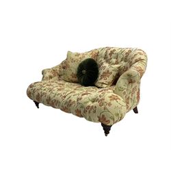 Victorian style two seat sofa, upholstered in beige ground floral floral pattern fabric, with scatter cushions, turned feet with brass castors