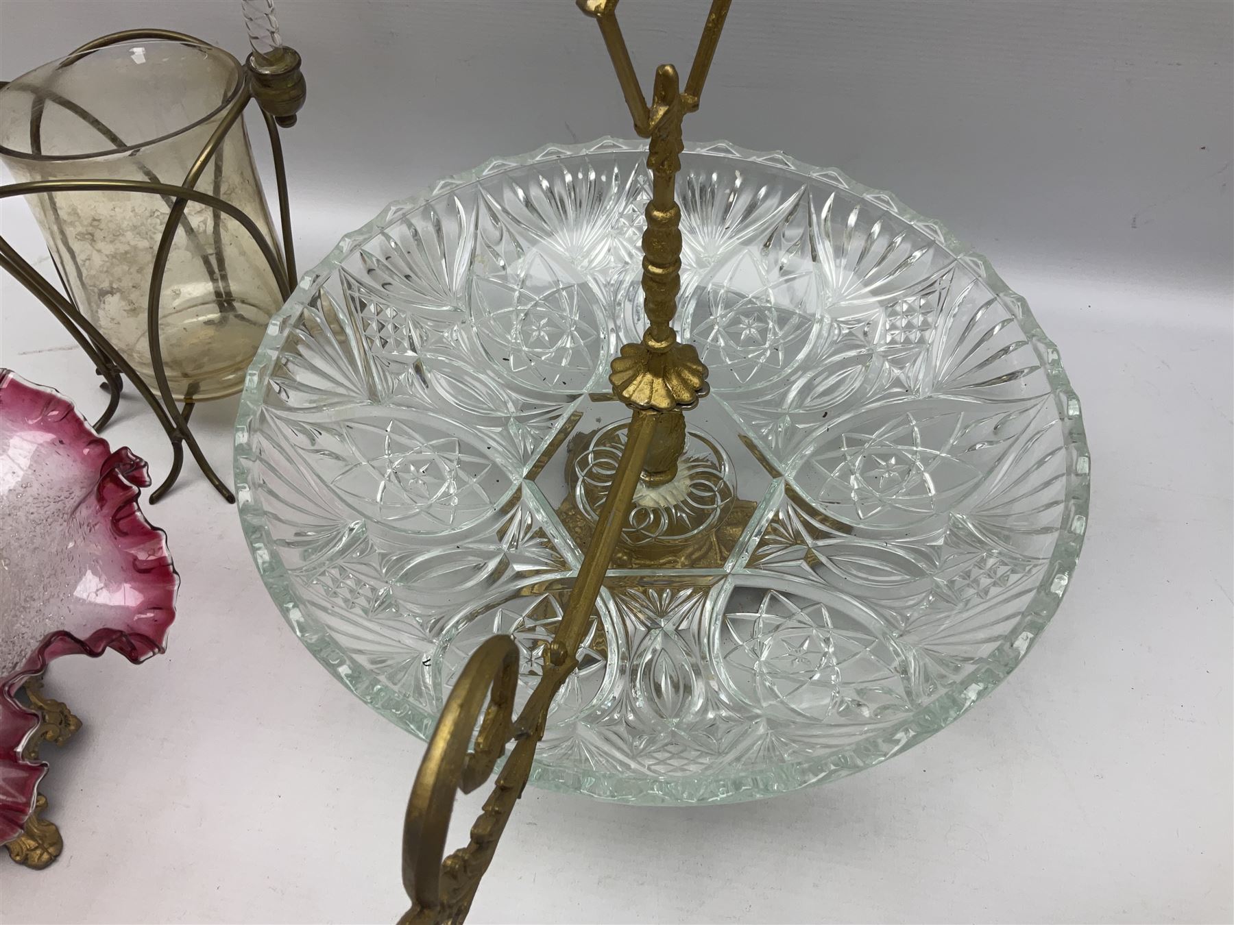 20th century moulded glass and gilt centre piece bowl with carrying handle and ornate trefoil base, together with frilled cranberry edge glass comport with ornate gilt base, and further centre piece with  large glass handle of twisted form, tallest H54cm