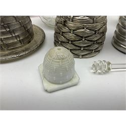Collection of glass beehive honey pots, to include a blue slag example, milk glass, pink, green, etc together with four white metal examples (16) 
