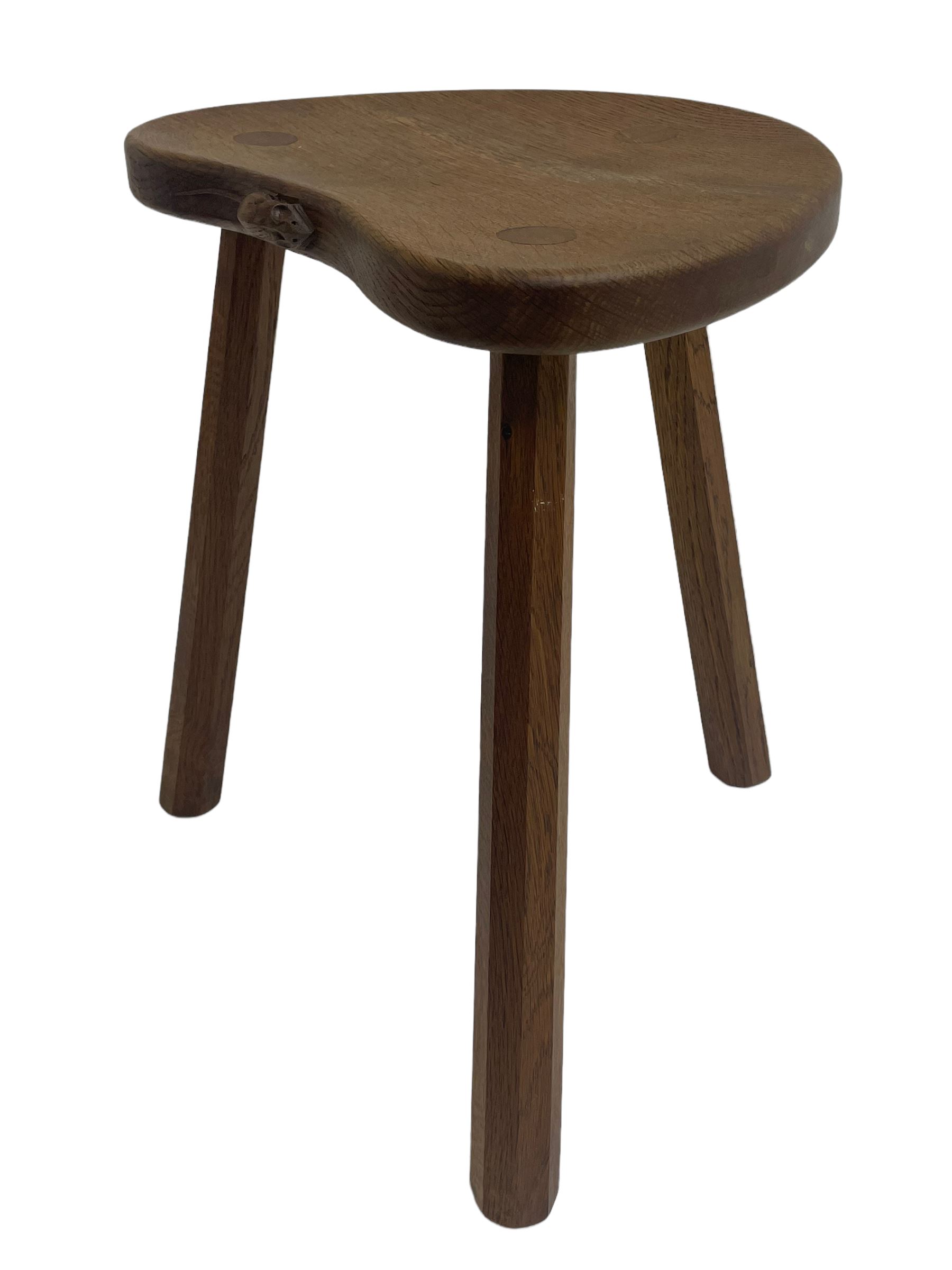 'Mouseman' oak three-legged stool, kidney shaped dished seat carved with mouse signature to edge, by Robert Thomas of Kilburn