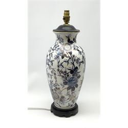 An Oriental style table lamp, of baluster form decorated with blue flowers upon a white ground and heightened with gilt, with pink shade, lamp base including fitting H49cm.